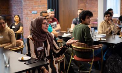 Student talking and smiling at social event.