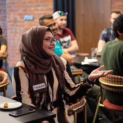 Student talking and smiling at social event.