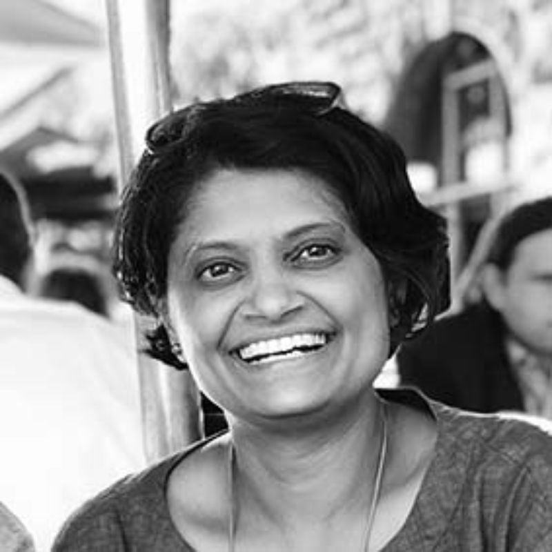 Profile photo of Mittul Vahanvati. Photo is in black an white. Background is out of focus, but people can be seen standing around. Mittul is looking slightly off from where the camera is and smiling.