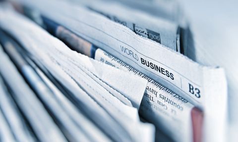 Photo of a collection of newspapers tightly packed together.
