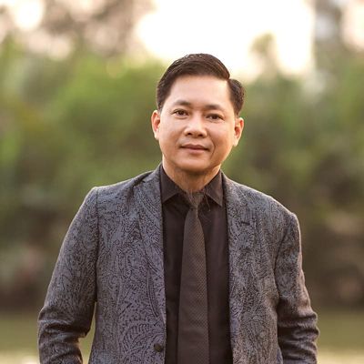 an asian man in suit smiling 