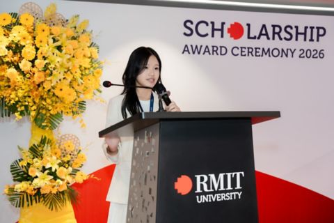 Vi speaking at a lectern