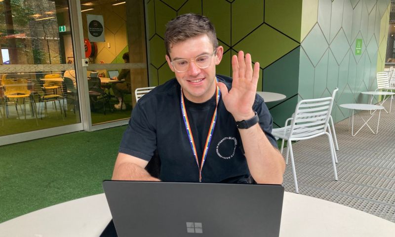 Student waving at someone on video call.