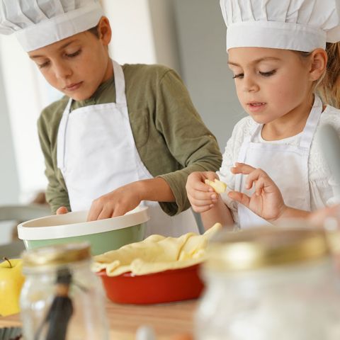 Kids in cooking class workshop preparing apple pie