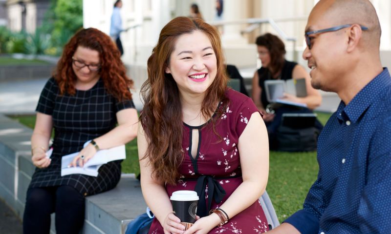 Students sitting outside with coffee