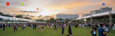 Crowd enjoying the RMIT Carnival outdoors at sunset.