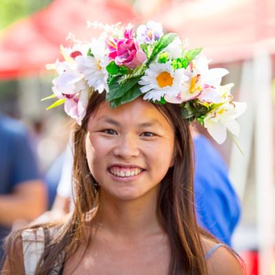 A female student wearing a flower crown smiles at the camera.