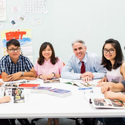 English students in a group with their teacher during class