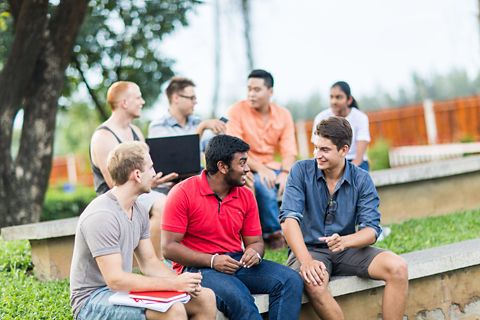 A group of international students talking while sitting outdoor