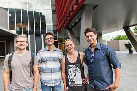A group of four international students smiling at the camera