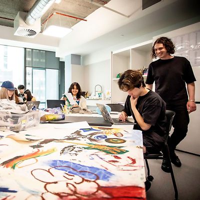 Teacher smiling in art class with students 