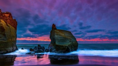 rocks_stones_on_ocean_waves_beach_sand_reflection_under_light_purple_clouds_sky_4k_hd_ocean.jpg
