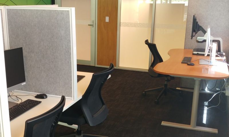 PC desk with partition and a stand up desk in Room 103.