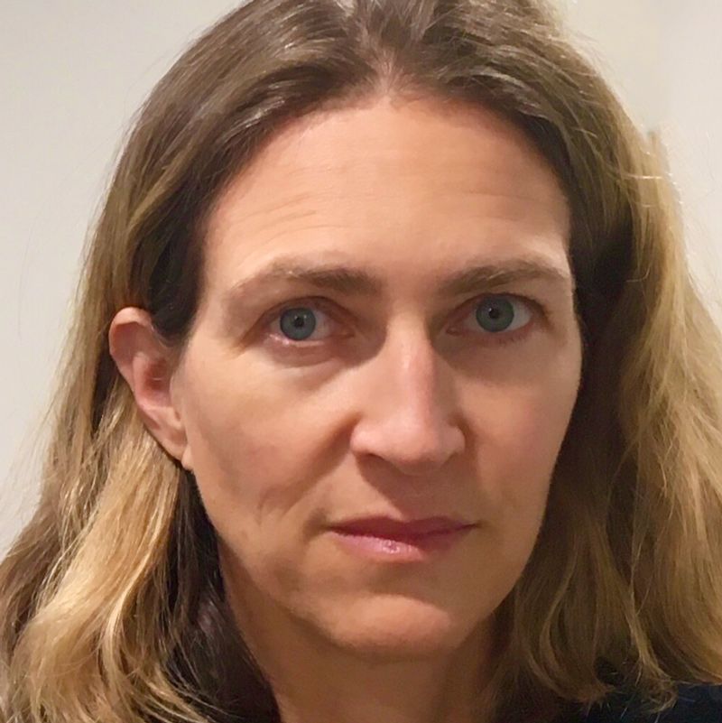 Profile photo of Sarah Tasley. Photo is a close up of Sarah's face and neck. Background is a plain beige wall. Sarah is looking straight at the camera.