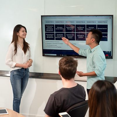 a group of students discussing work in a classroom