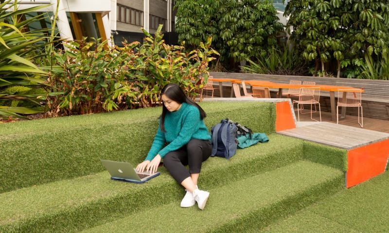 Student working on computer outside.