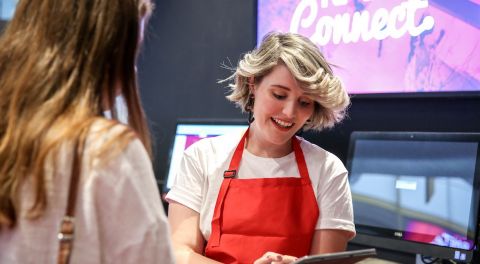 A woman with an iPad helps an RMIT student at Student Connect.