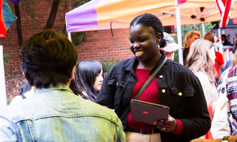 Student smiling and holding an iPad.