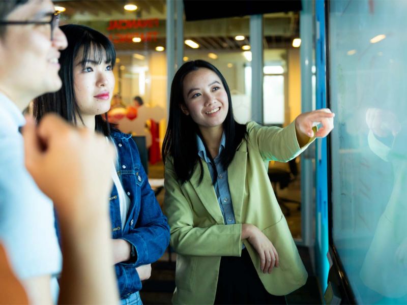 Students pointing at white board