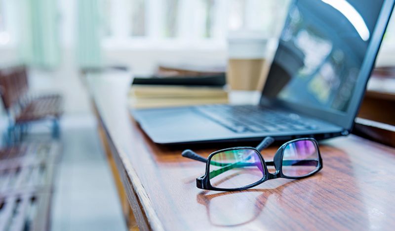 Glasses and laptop on desk