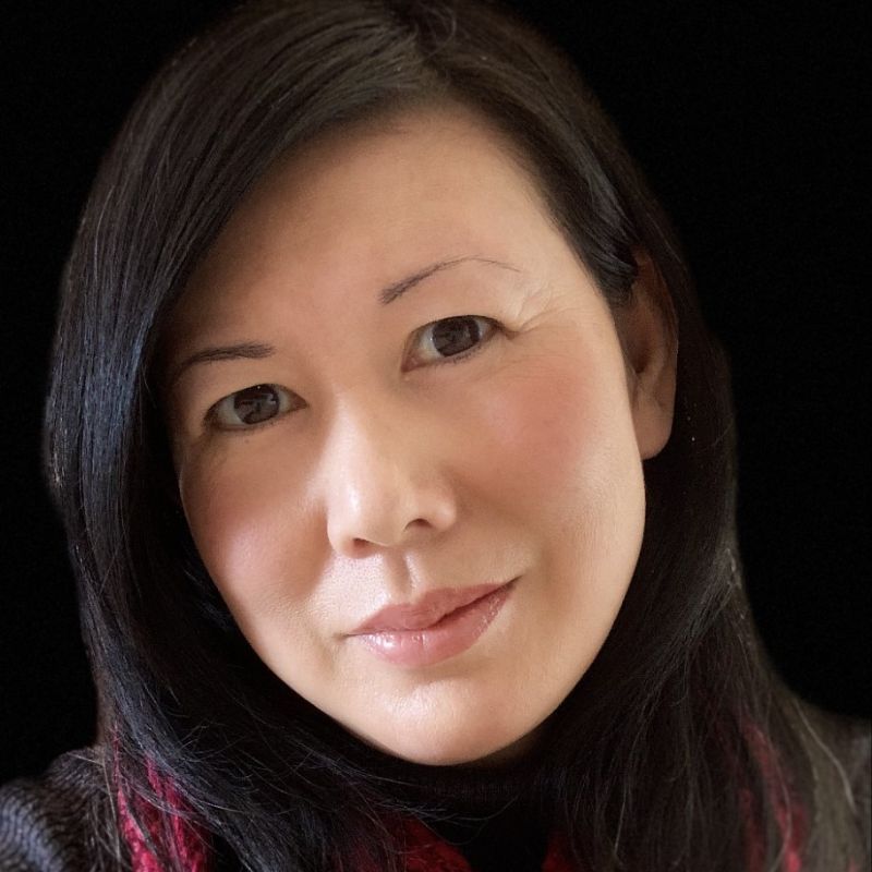 Profile photo of Dr Tammy Wong Hulbert. Tammy is looking directly at the camera and standing in front of black background. Tammy's head is slightly tilted.