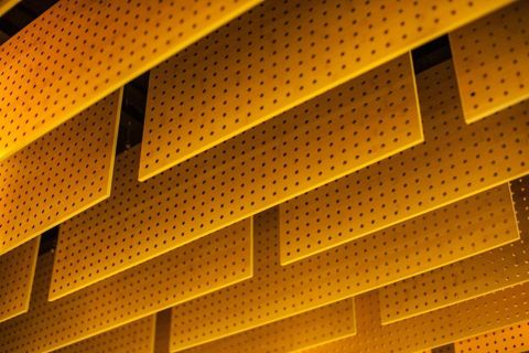 series of yellow panels with grids of holes viewed from below