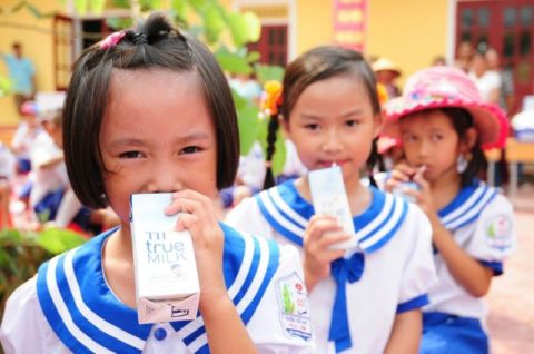 Schoolchildren drinking TH true MILK as part of a sustainable dairy development initiative promoting community health and nutrition in Vietnam