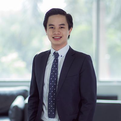 a headshot of an asian man in suit smiling 