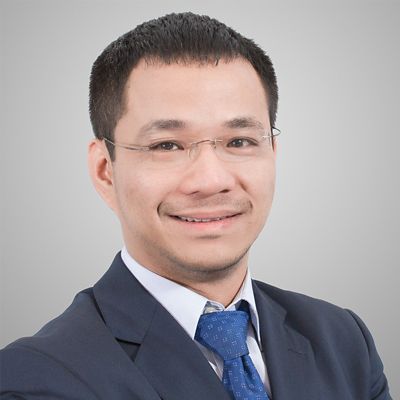 a headshot of an asian man in suit smiling 