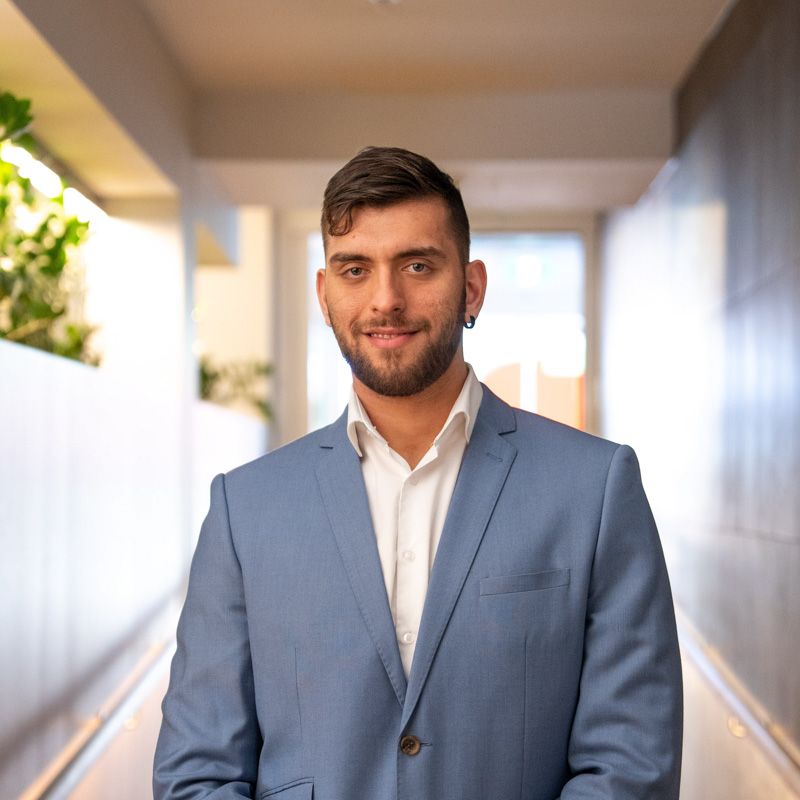 A portrait photograph of Vasilios smiling and looking directly at the camera.