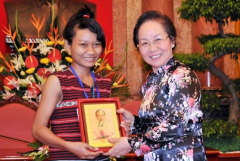 A student receives a scholarship award from the Vu A Dinh Scholarship Fund in recognition of academic achievement and perseverance in overcoming challenges