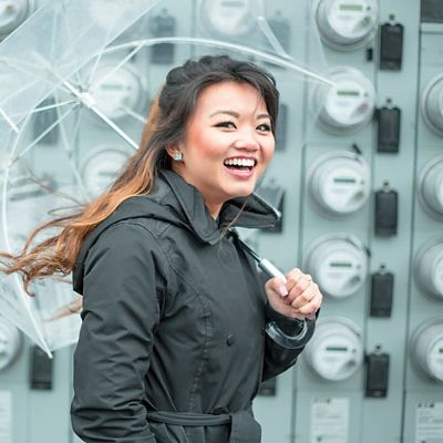 A woman carrying an umbrella smiling