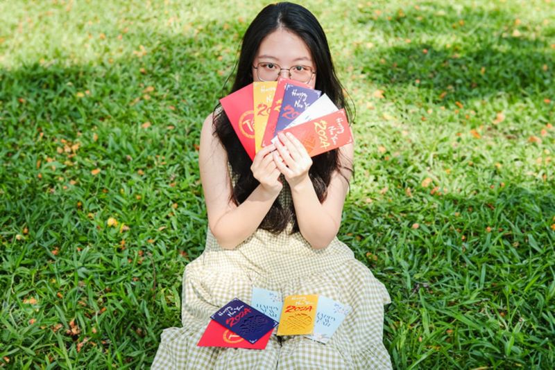 Young girl posing with lucky money envelopes