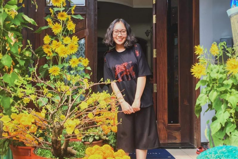 A girl posing with yellow flowers