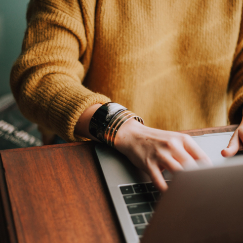 Woman typing on a laptop.