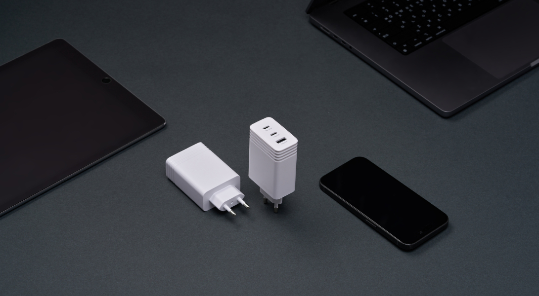 Multiple smart devices being charged at once using a single wall-mounted charger, emphasizing efficiency and compatibility.