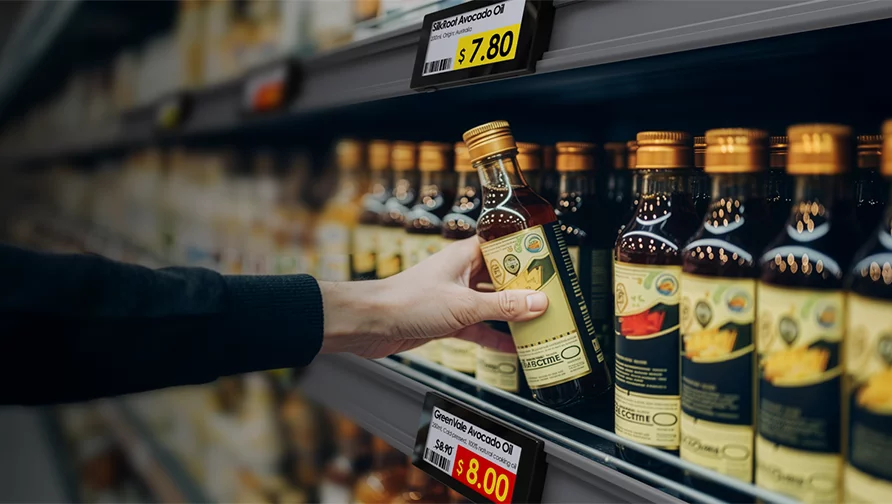 Customer selecting a product from a shelf with Solum digital labels showing live pricing