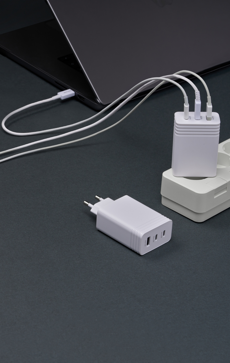 Three devices charging from one wall-mounted multi-port charger.