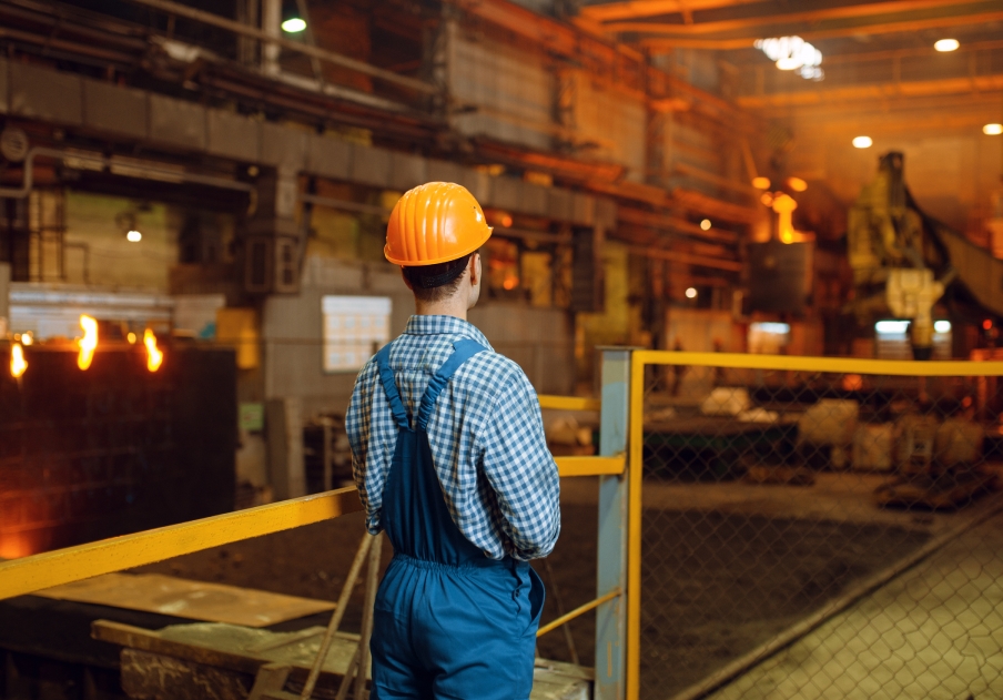 Worker checking industrial temperature from behind.