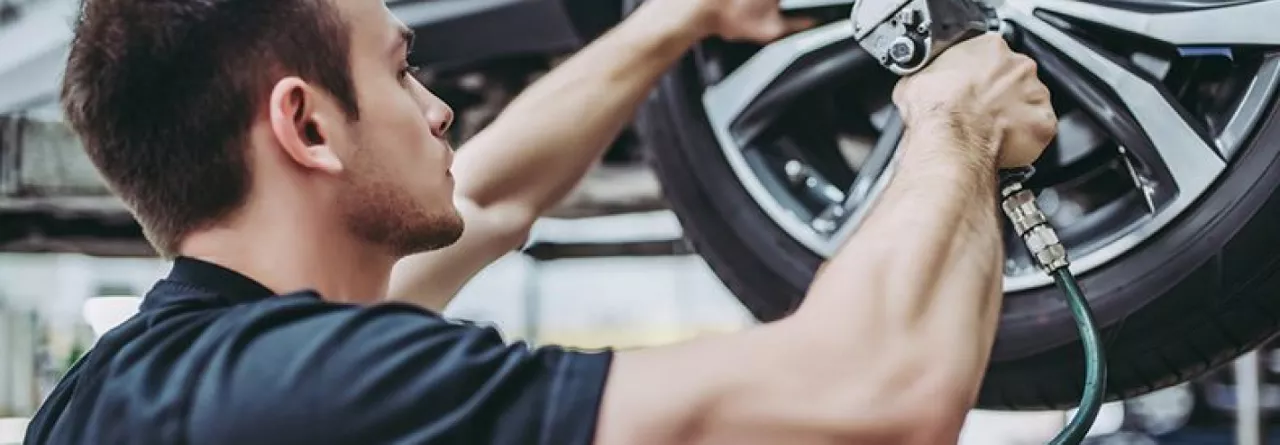 Mechanic tightening a car tire Image