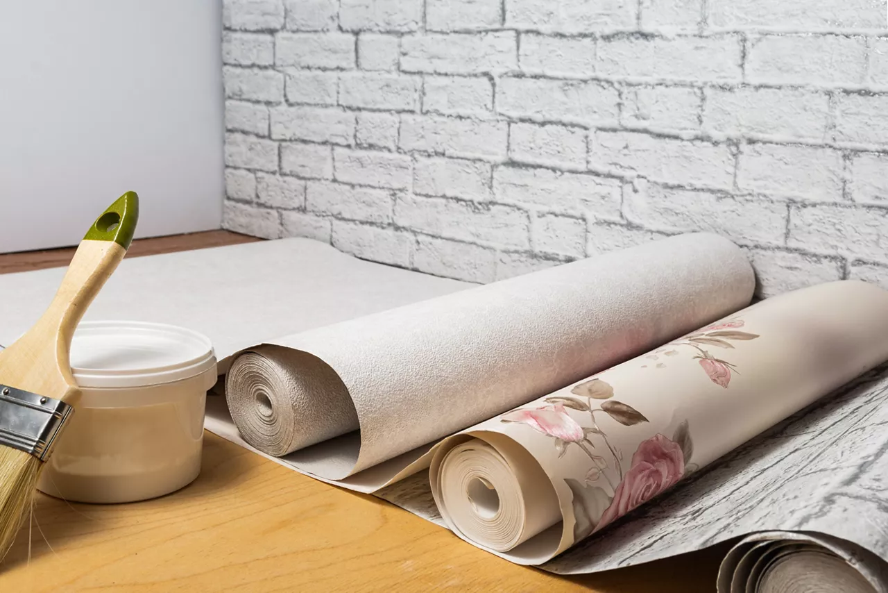 Multicolored patterned wallpaper, brush, glue are prepared for home interior renovation. Home renovation concept.