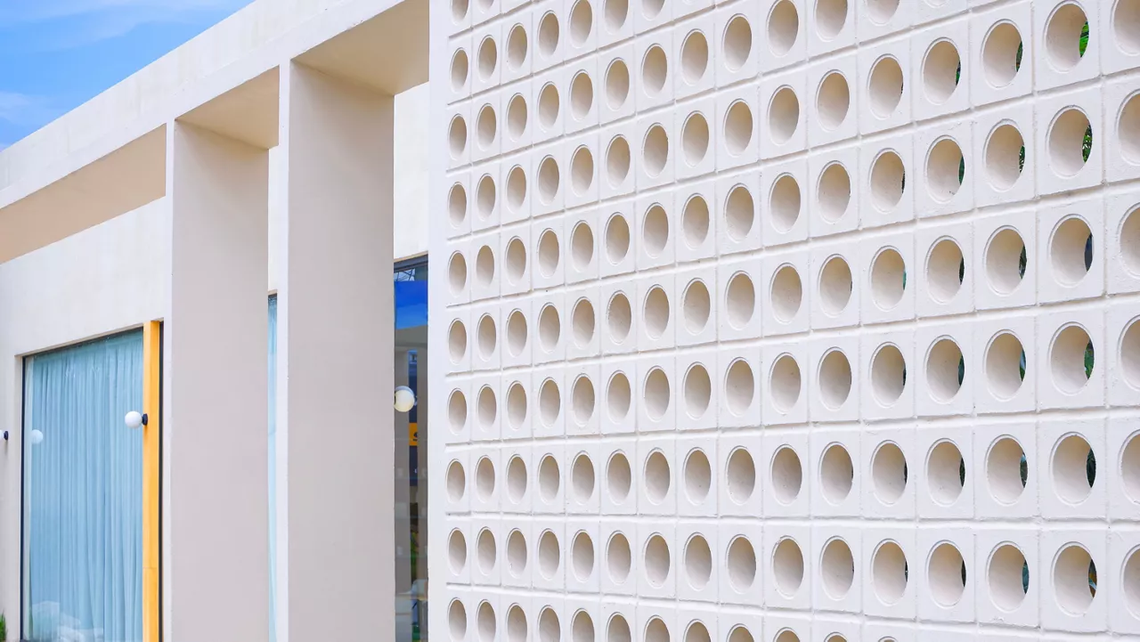 Ventilation block on beige fence wall decoration in front of modern coffee shop, perspective side view