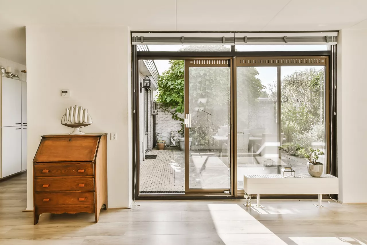 a living room with sliding glass doors that open up to the patio and backyard area in the house is white