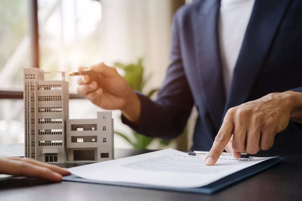 Considering buying a home, investing in real estate. Broker signs a sales agreement. agent, lease agreement, successful deal.