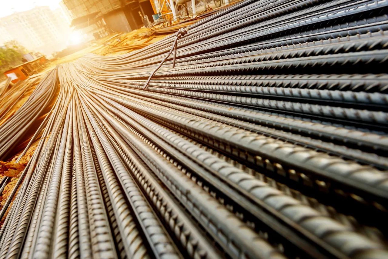 steel rebar for reinforcement concrete at construction site with house under construction background