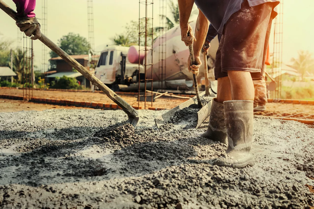pouring concrete with worker mix cement at construction site