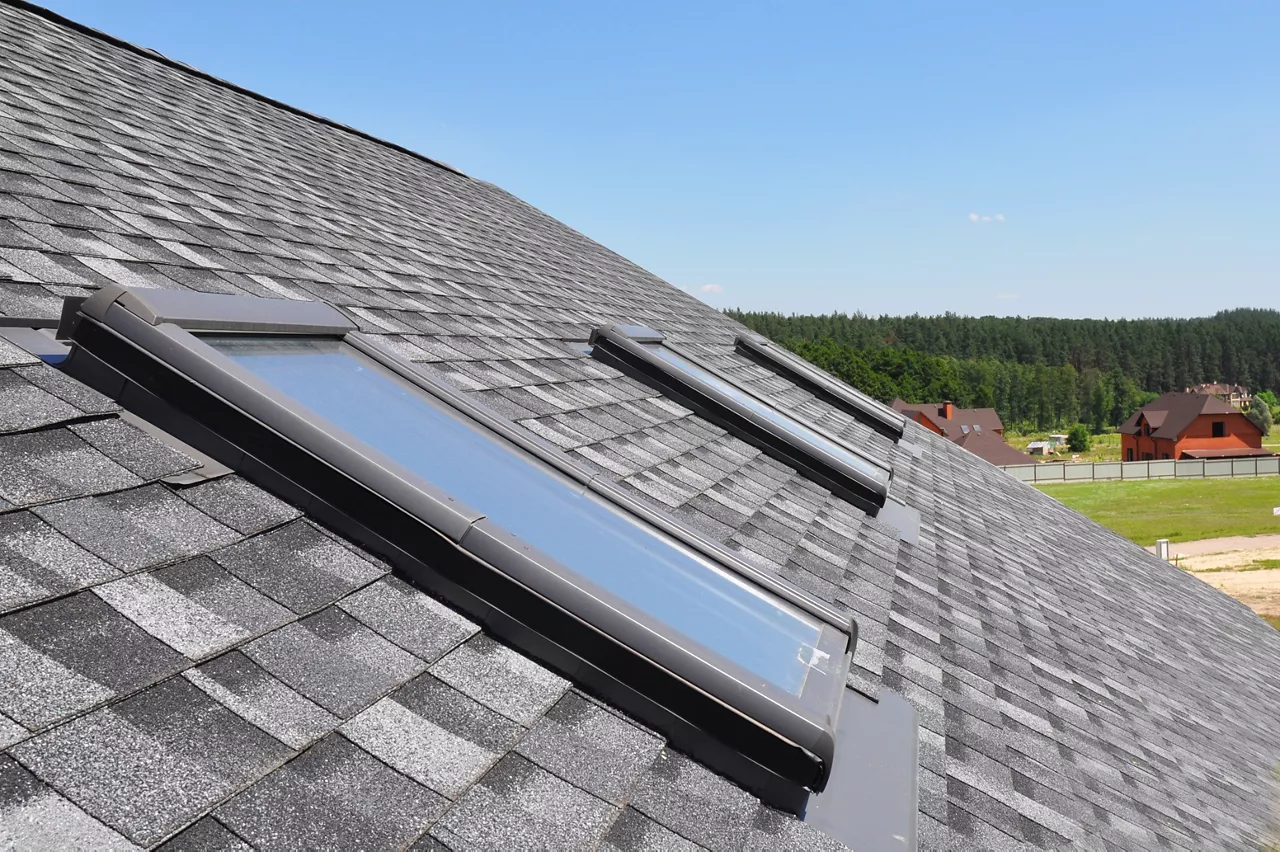Attic skylight. Asphalt Shingles House Roofing Construction with Attic Roof windows, skylights waterproofing.