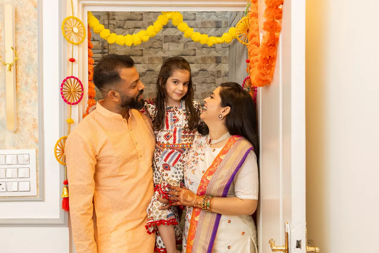 Happy indian family of three entering new house for the first time. festival purchase , family relationship concept