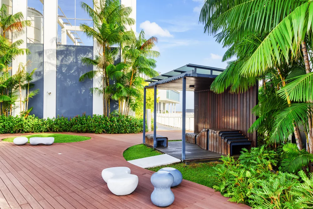Beautiful rooftop garden. Outside terrace with amazing park. Modern wooden arbor among green trees. Urban eco design and mini-ecosystem. Landscaping in Singapore.