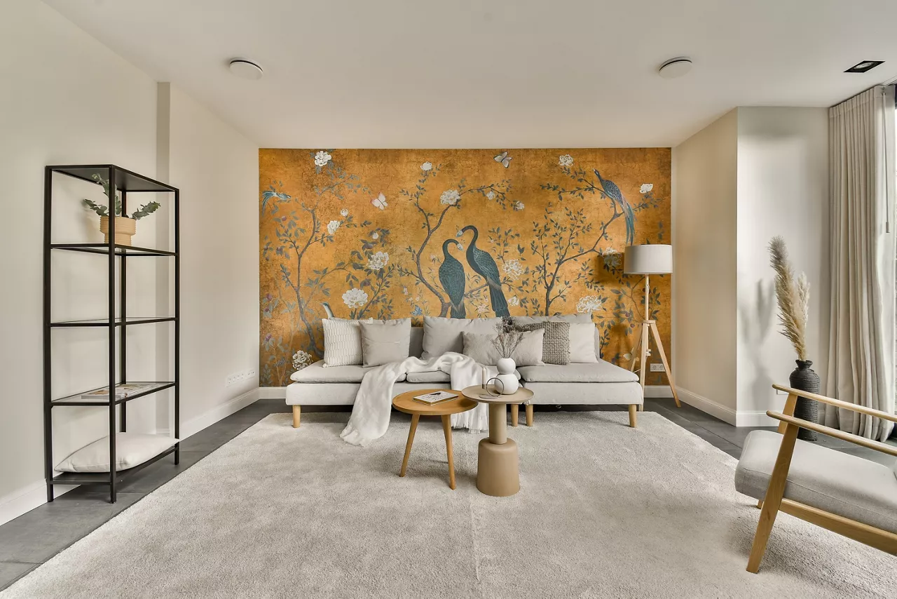a bird painted on the wall in a living room with two chairs and a coffee table sitting next to it